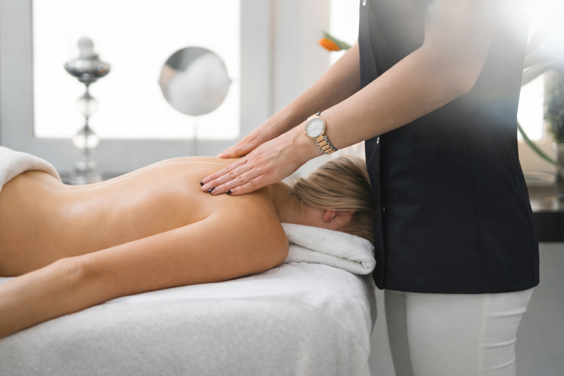 spa massage table with therapist performing treatment showing cushioning support and upholstery quality in a professional spa setting