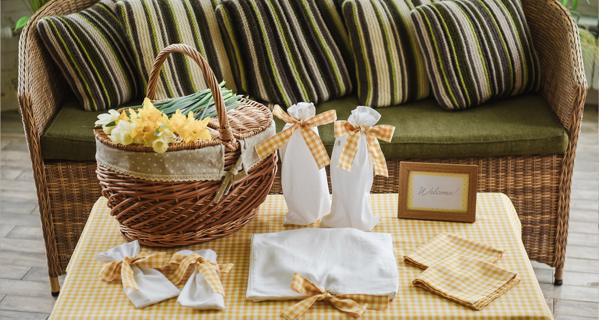 Airbnb welcome kit with flowers, bottled drinks, and handwritten note on a table