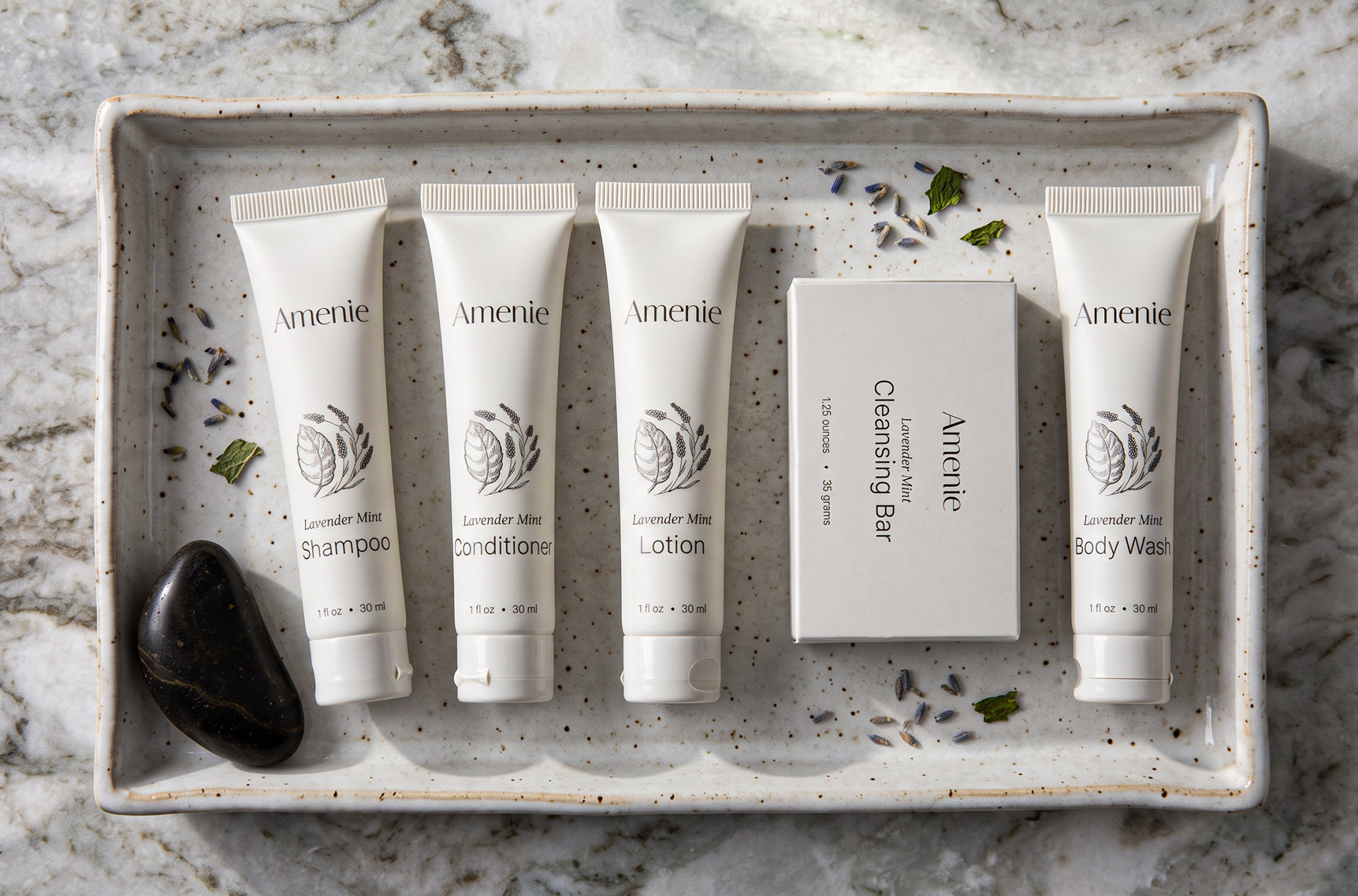 Single-use hotel amenity bottles arranged on a bathroom counter