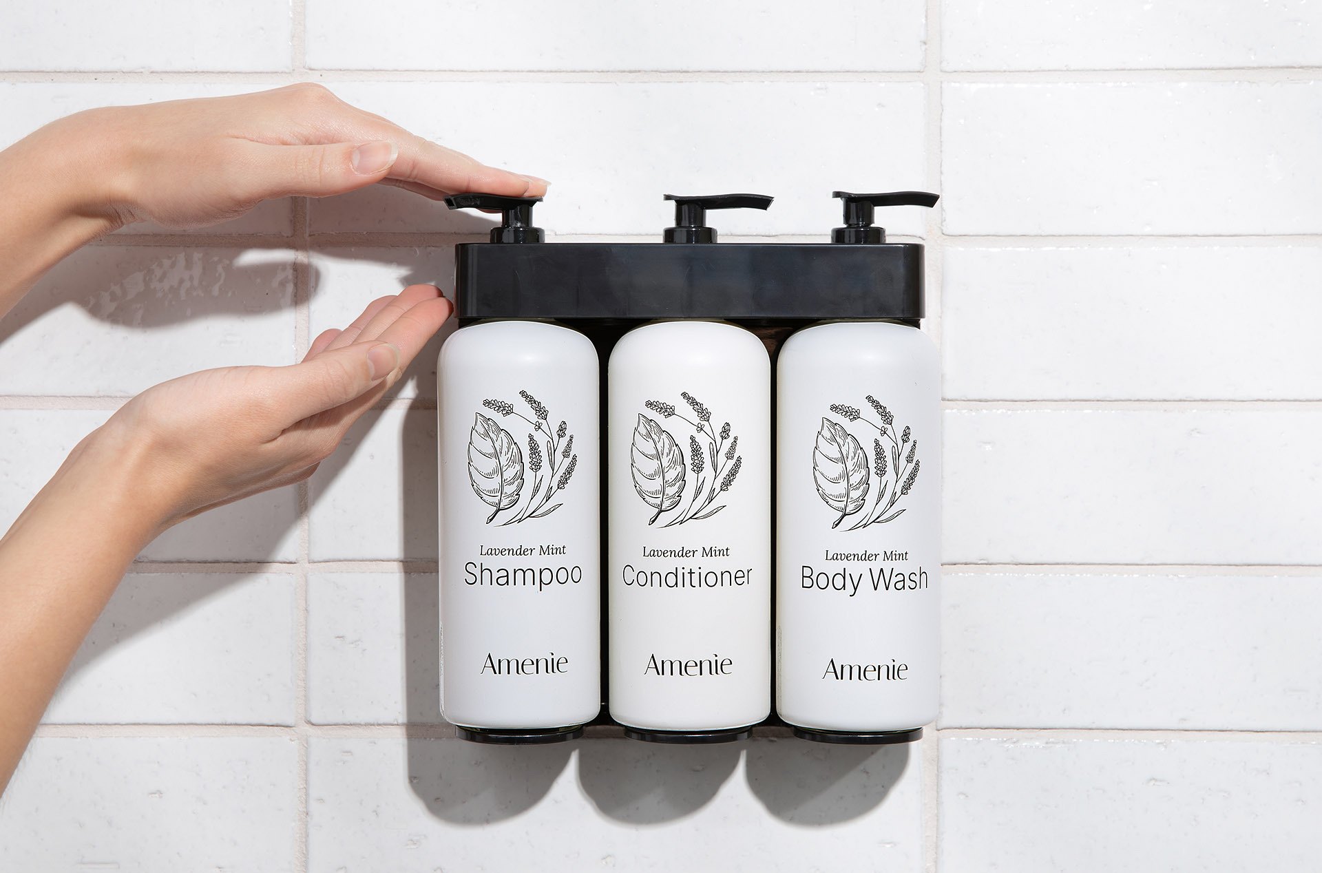 Wall-mounted Lavender Mint shampoo, conditioner, and body wash dispensers installed in an Airbnb shower