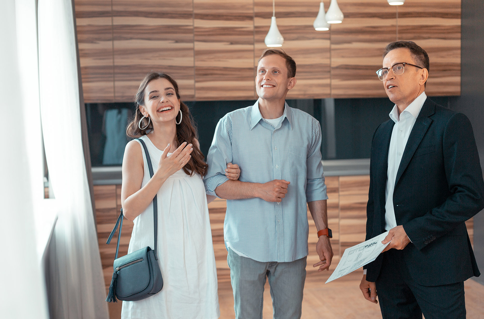 Smiling guests touring a short-term rental with the host or property manager.