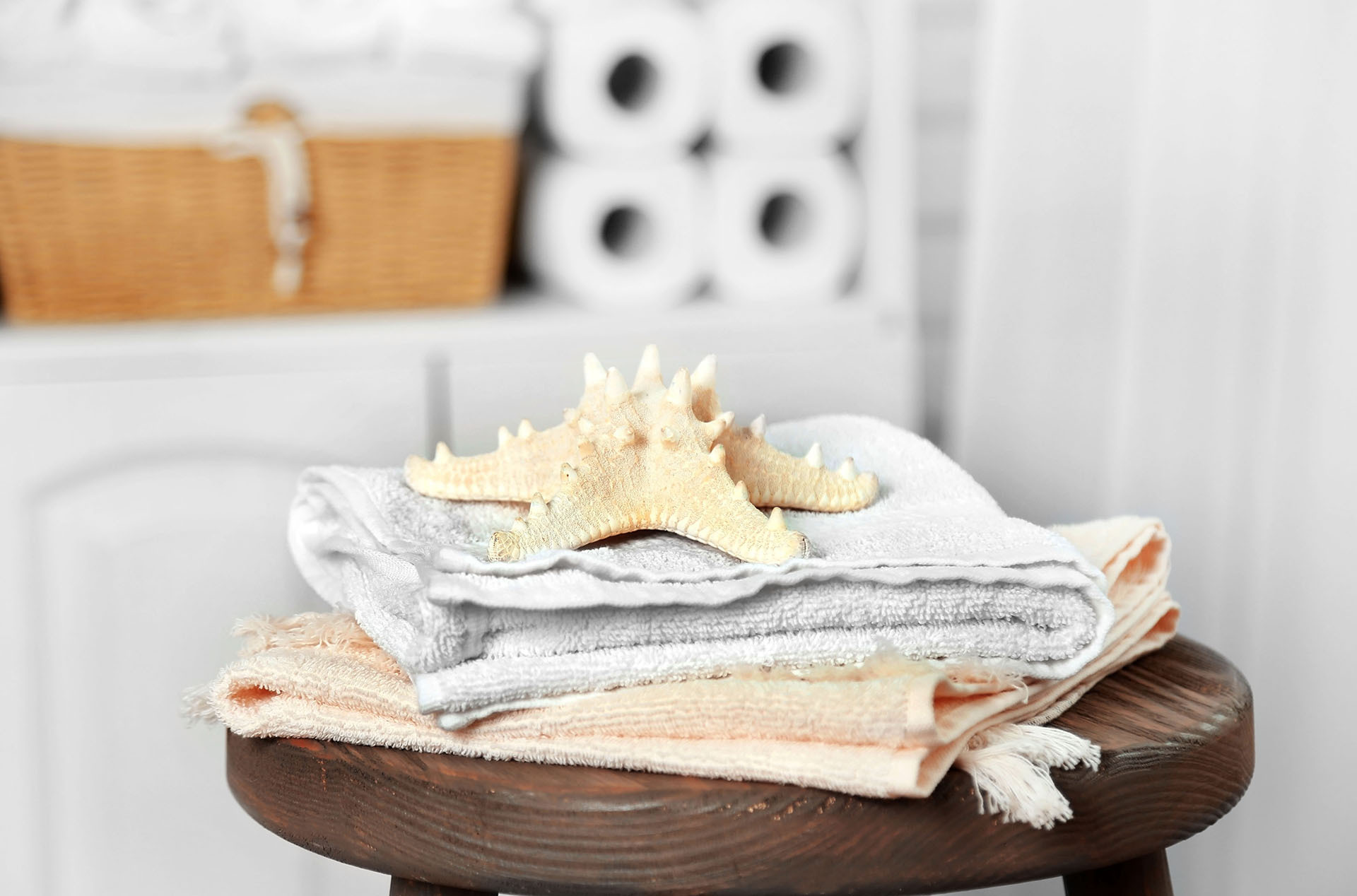 Airbnb bathroom towels with coastal starfish decor—clean, guest-ready setup that signals a well-stocked vacation rental.